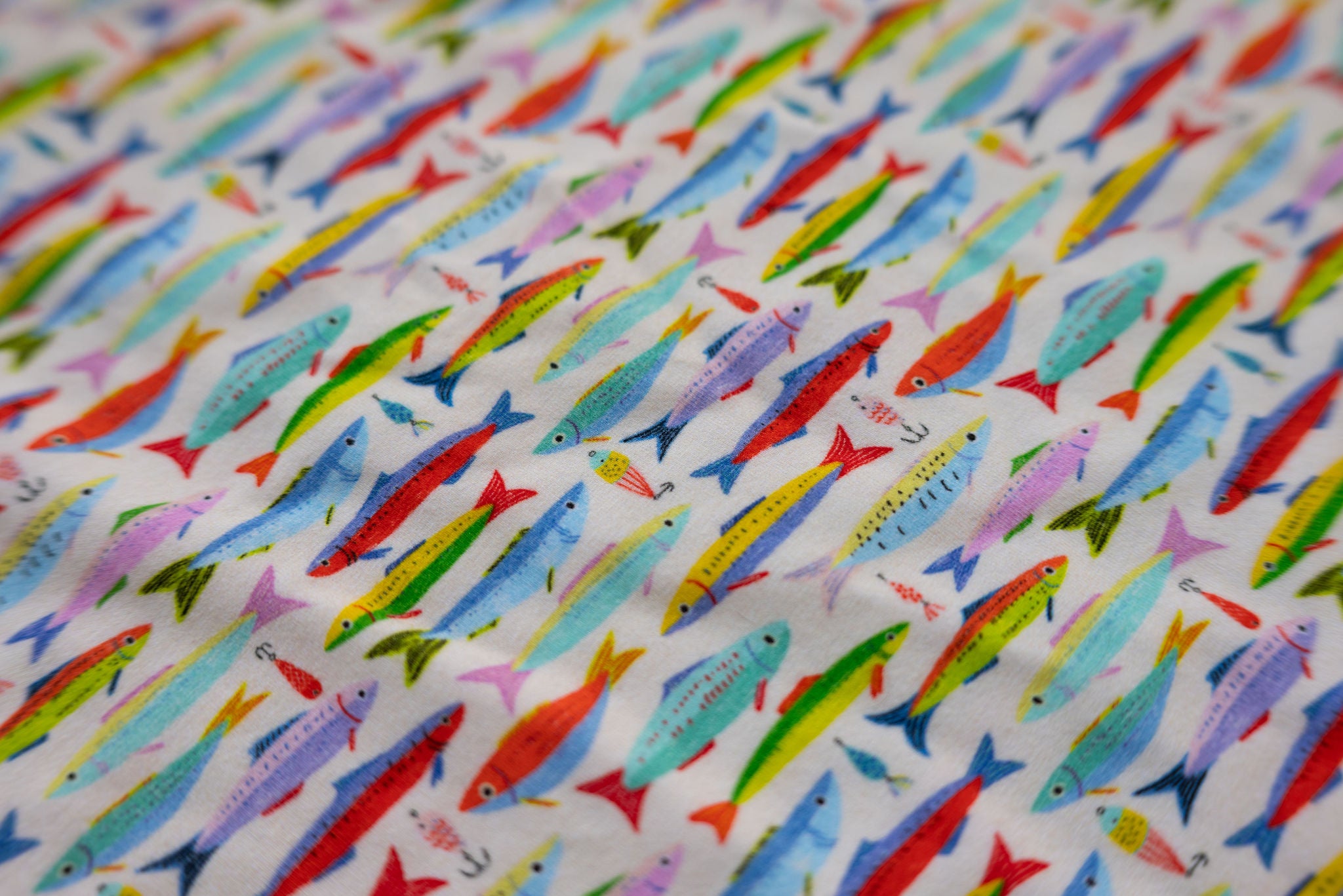 A playful, coastal-inspired print featuring hand-drawn fish and vintage fishing lures in a lively mix of sun-washed colors.